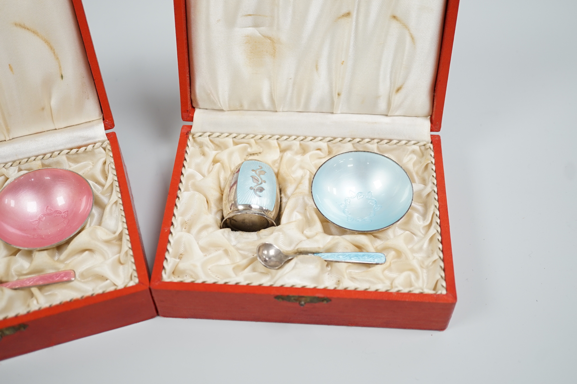 Three cased Danish sterling and enamel three piece condiments sets, by Volmer Bahner & Co, each with different coloured enamel and comprising a salt, pepper and spoon